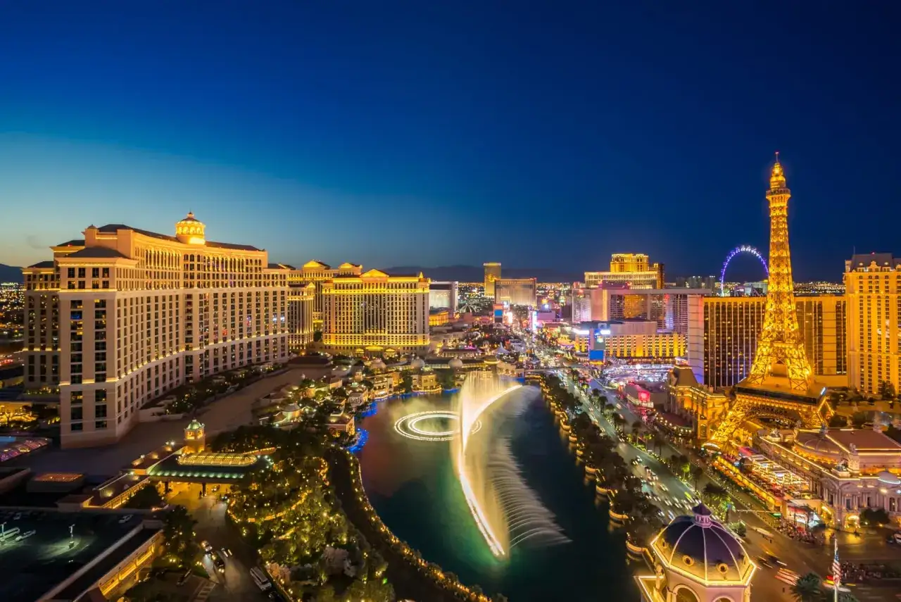 Nocny widok Las Vegas z fontannami i wieżą Eiffla. Niezliczone las vegas atrakcje w blasku świateł.