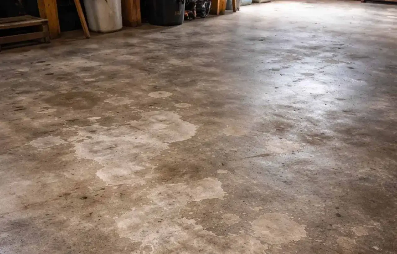 Pavimenti in cemento con macchie chiare, forse residui di acido muriatico.