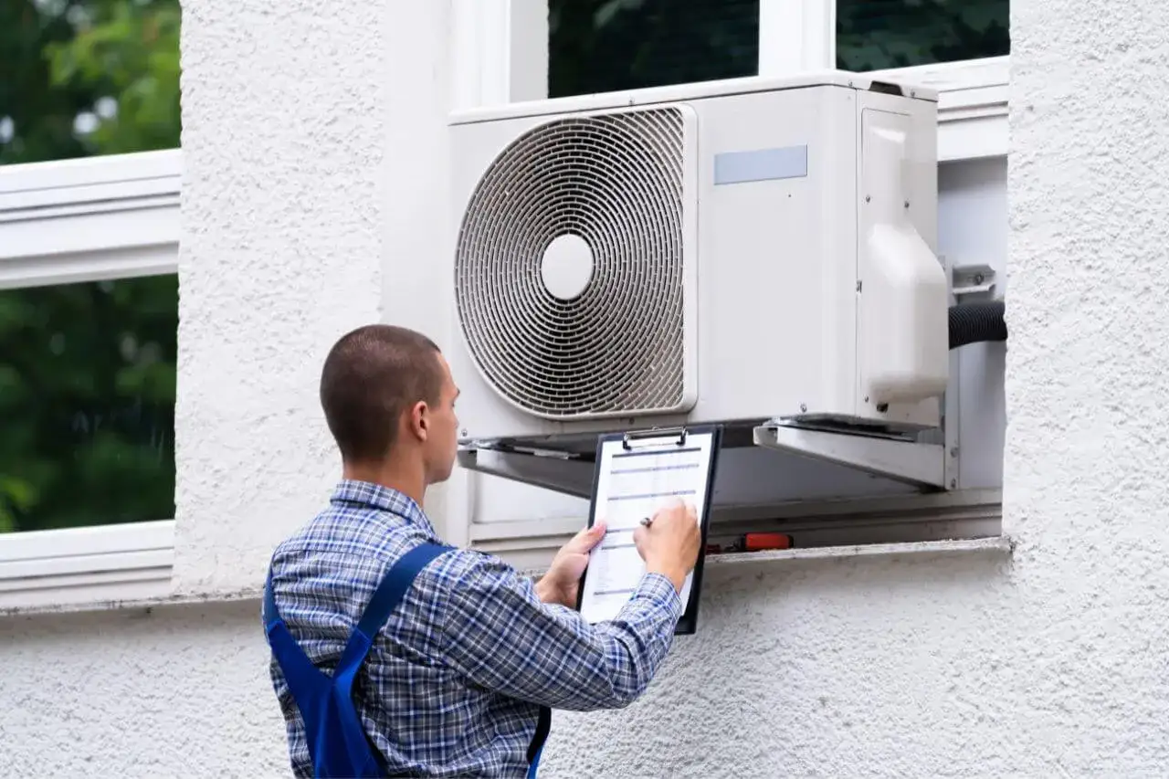 Instalator klimatyzacji podczas pracy przy jednostce zewnętrznej