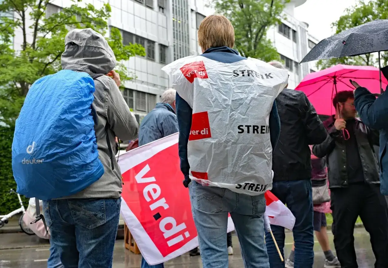 Menschen mit Regenschirmen und Fahnen, die 