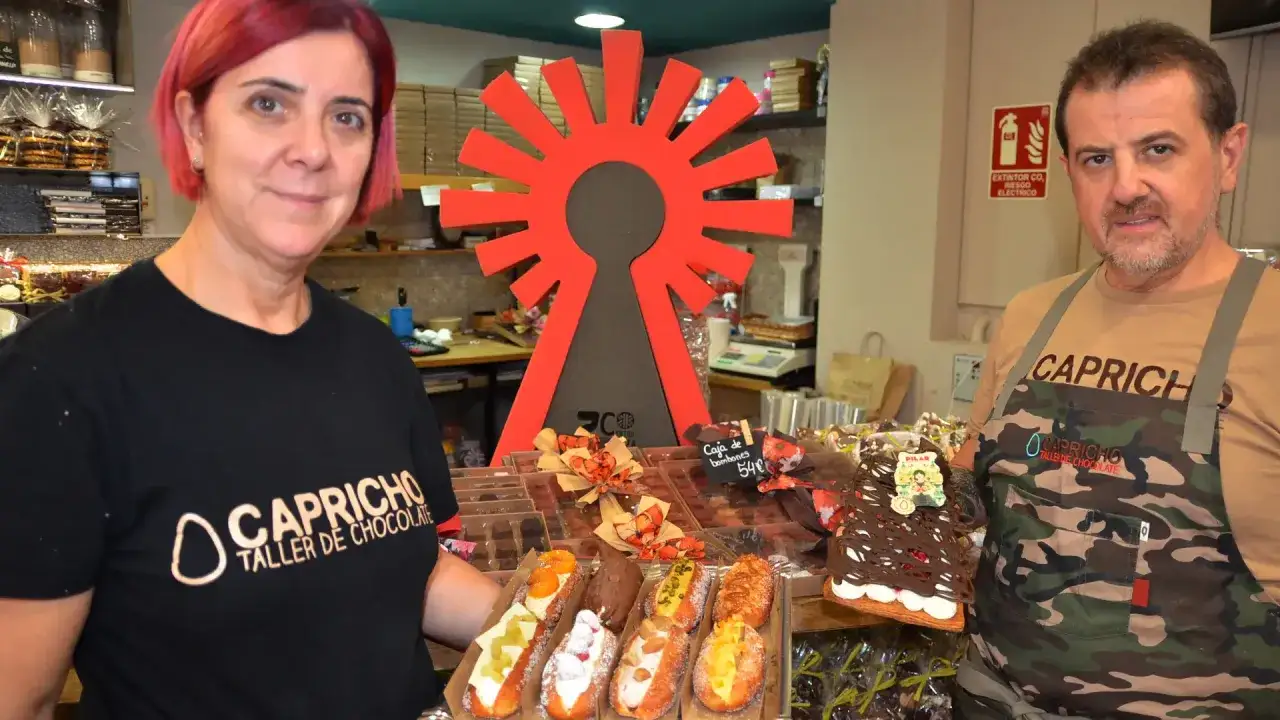 Pareja sonriente en Capricho Taller de Chocolate, Zaragoza. Exhiben dulces y chocolates, un paraíso para los amantes del dulce.