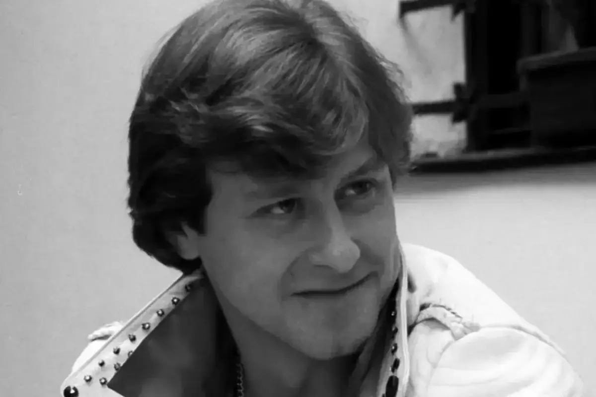 Uśmiechnięty mężczyzna w skórzanej kurtce z ćwiekami, jak z filmu 
