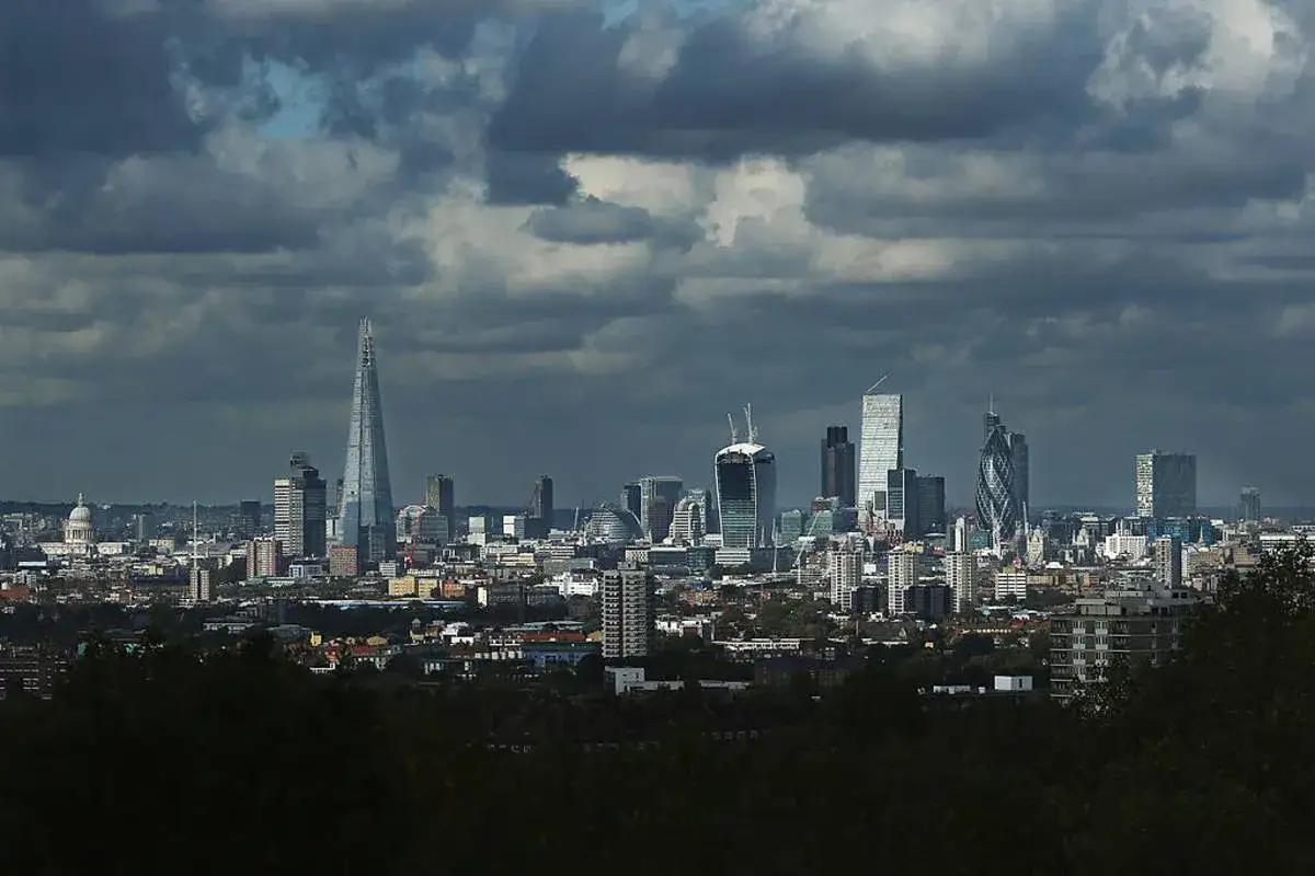 Londyn blog: panorama miasta z charakterystycznym budynkiem The Shard i innymi drapaczami chmur pod burzowym niebem.