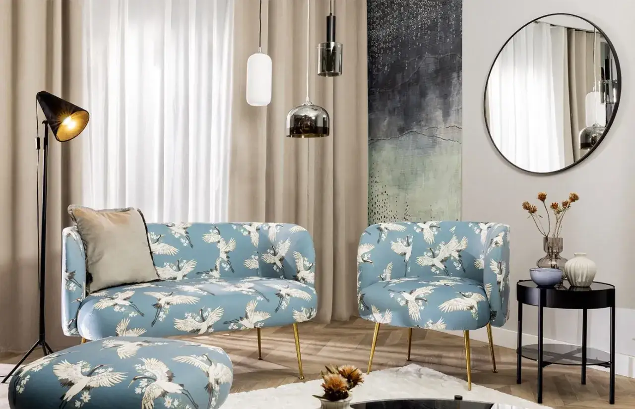 Eleganckie lustro glamour do salonu, wiszące nad błękitną sofą w żurawie.