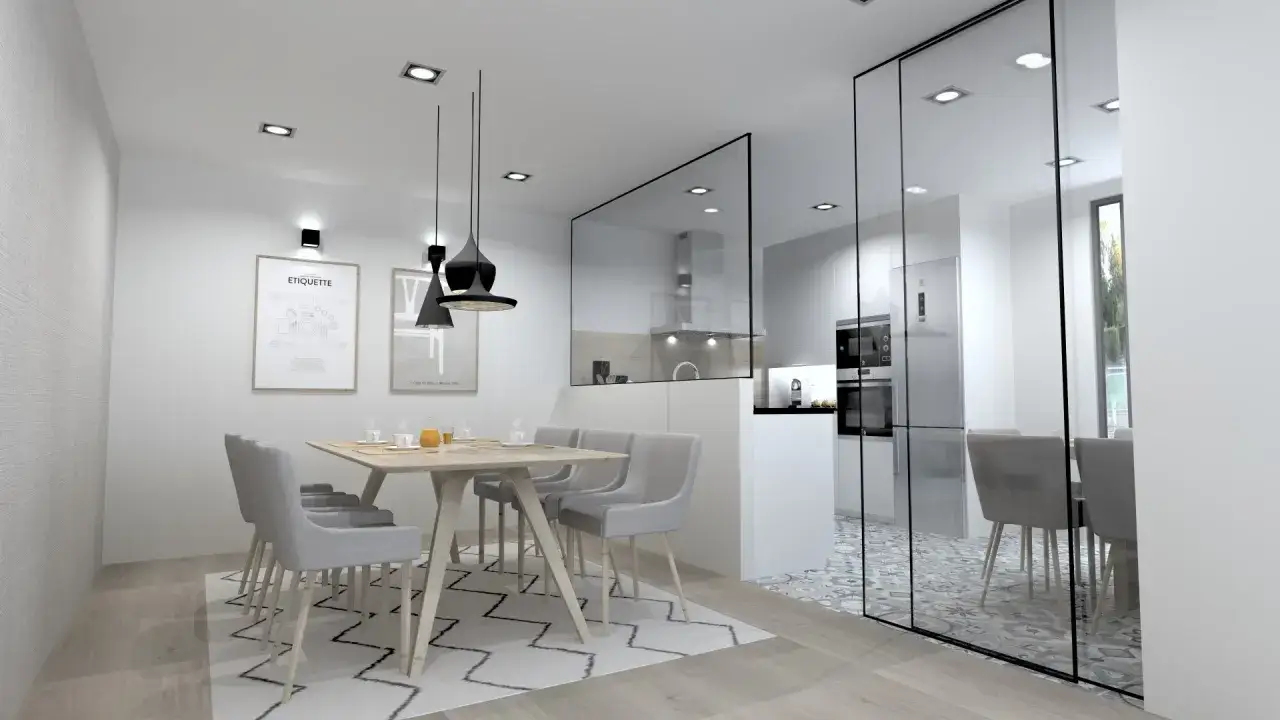 Un tabique de cocina semiabierta al sal&oacute;n, con una mesa de comedor y sillas grises, y una cocina moderna detr&aacute;s de un cristal.