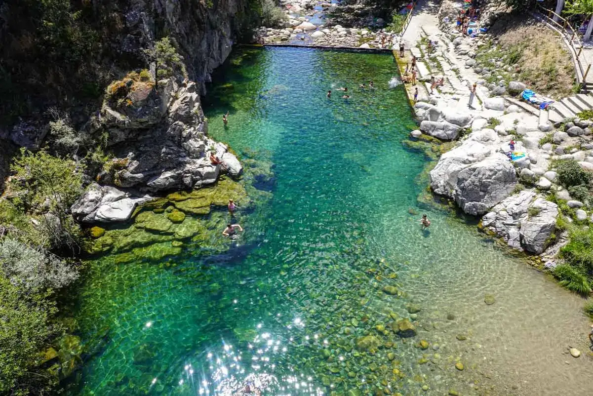 Un refrescante ba&ntilde;o en una piscina natural de Extremadura, con aguas cristalinas y rodeada de rocas y vegetaci&oacute;n.