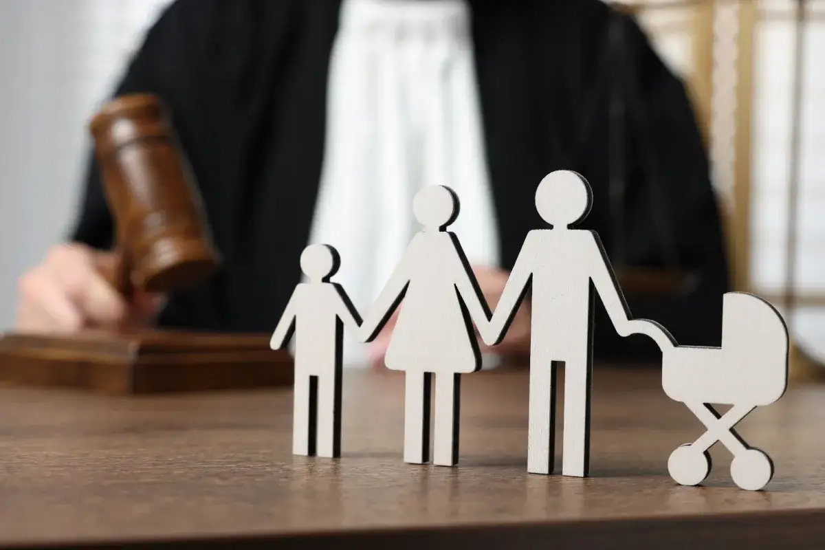 Figurines de famille sur un bureau de juge, avec un maillet en arrière-plan. La question se pose : peut-on refuser une séparation de corps ?