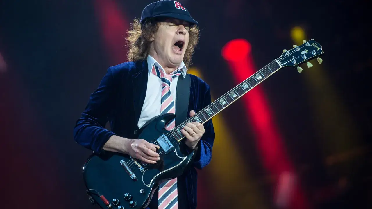 Angus Young von AC/DC spielt seine ikonische Gibson SG Gitarre auf der Bühne.