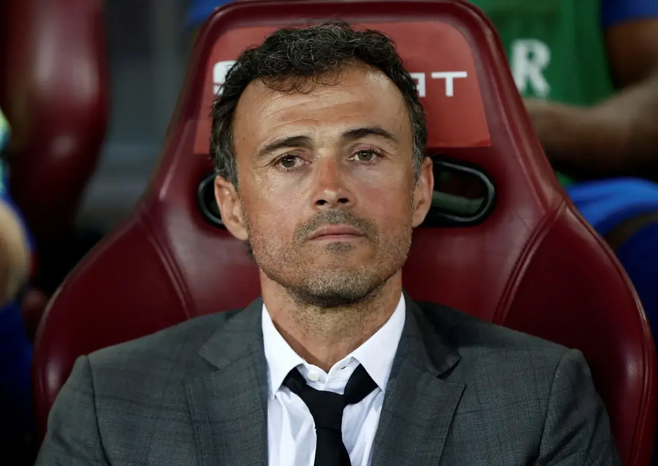 Luis Enrique, jeden z trenerów reprezentacji Hiszpanii, siedzi na czerwonym krześle w garniturze.