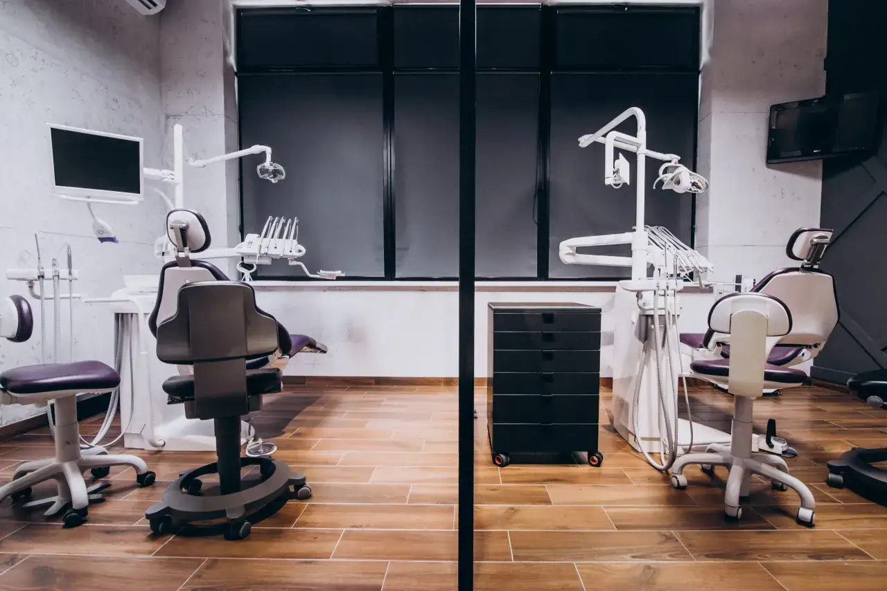 Nowoczesny gabinet stomatologiczny z dwoma fotelami, sprzętem i monitorem. Idealne miejsce na leasing dla lekarza.