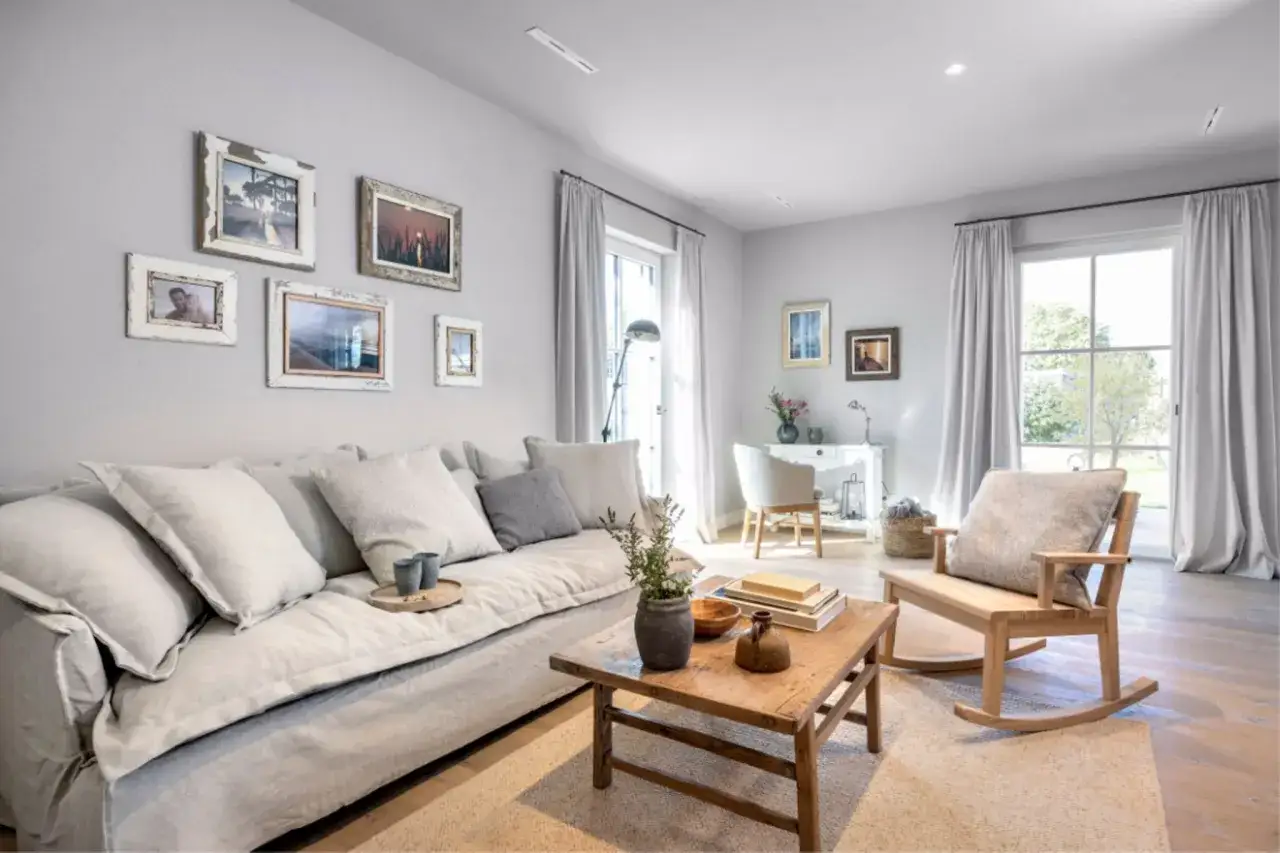 Gem&uuml;tliches Wohnzimmer mit einem gro&szlig;en, grauen Sofa, rustikalem Couchtisch und Bildergalerie an der Wand. Tolle Wohnzimmer Ideen!