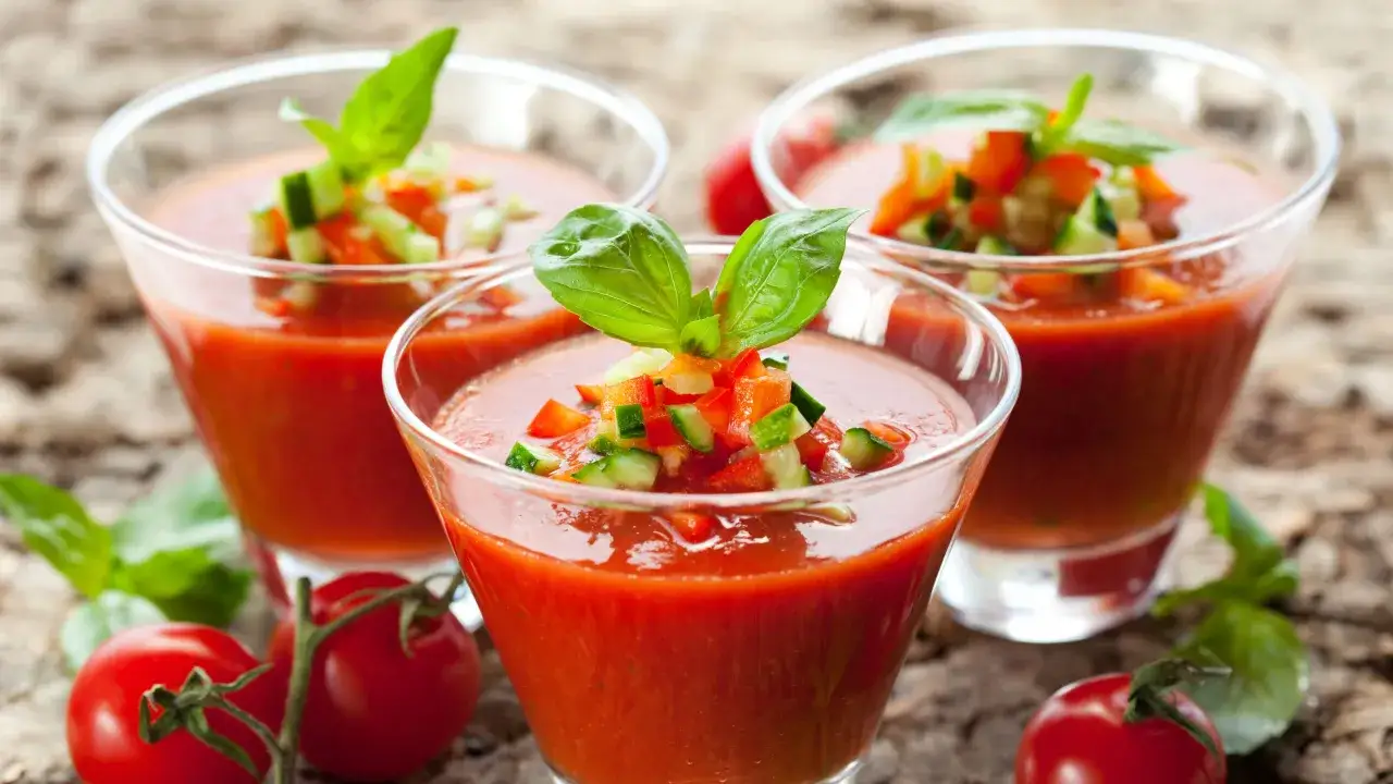 Tre glas med gazpacho, toppad med tärnad gurka, paprika och basilika. Perfekt för ett svalkande gazpacho recept.