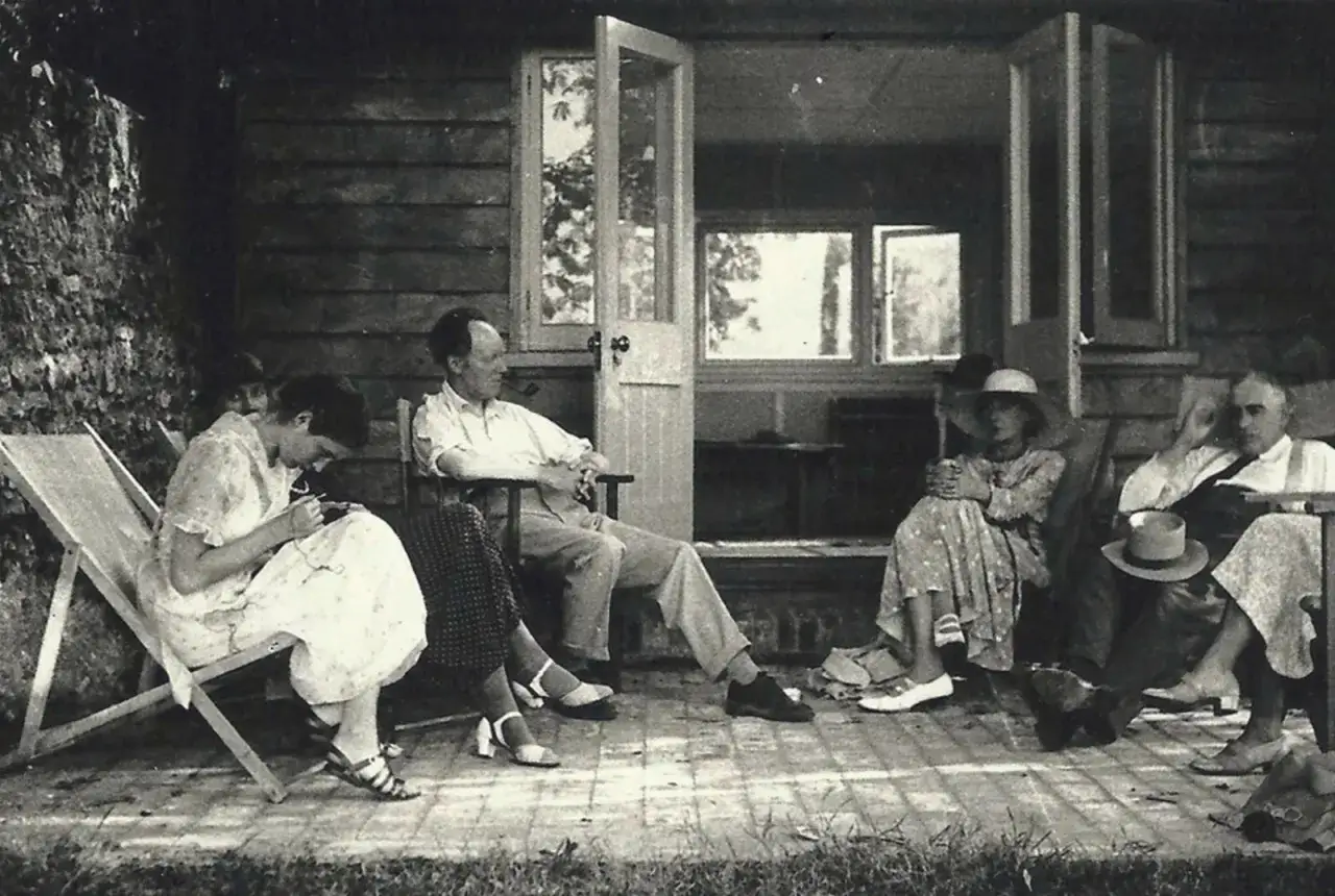 Un gruppo di persone rilassate su una veranda. Un'immagine che evoca la serenit&agrave; prima della tragica morte di Virginia Woolf.