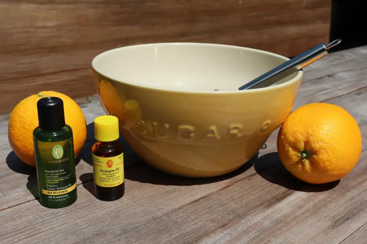Zutaten f&uuml;r selbstgemachtes Saunasalz: Orangen, Mandel&ouml;l und Orangen&ouml;l liegen neben einer Sch&uuml;ssel.