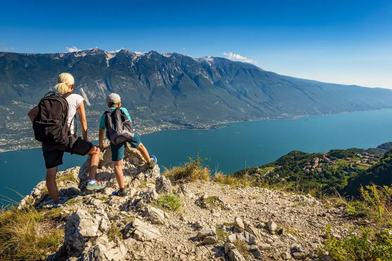 Madre e figlio ammirano il panorama del Lago di Garda durante leggere escursioni. Montagne imponenti e un lago azzurro scintillante.