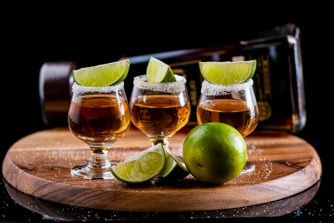 Trzy kieliszki tequili z solą na rancie i ćwiartkami limonki. Czy sól na rancie szklanki faktycznie wzmacnia smak tequili?