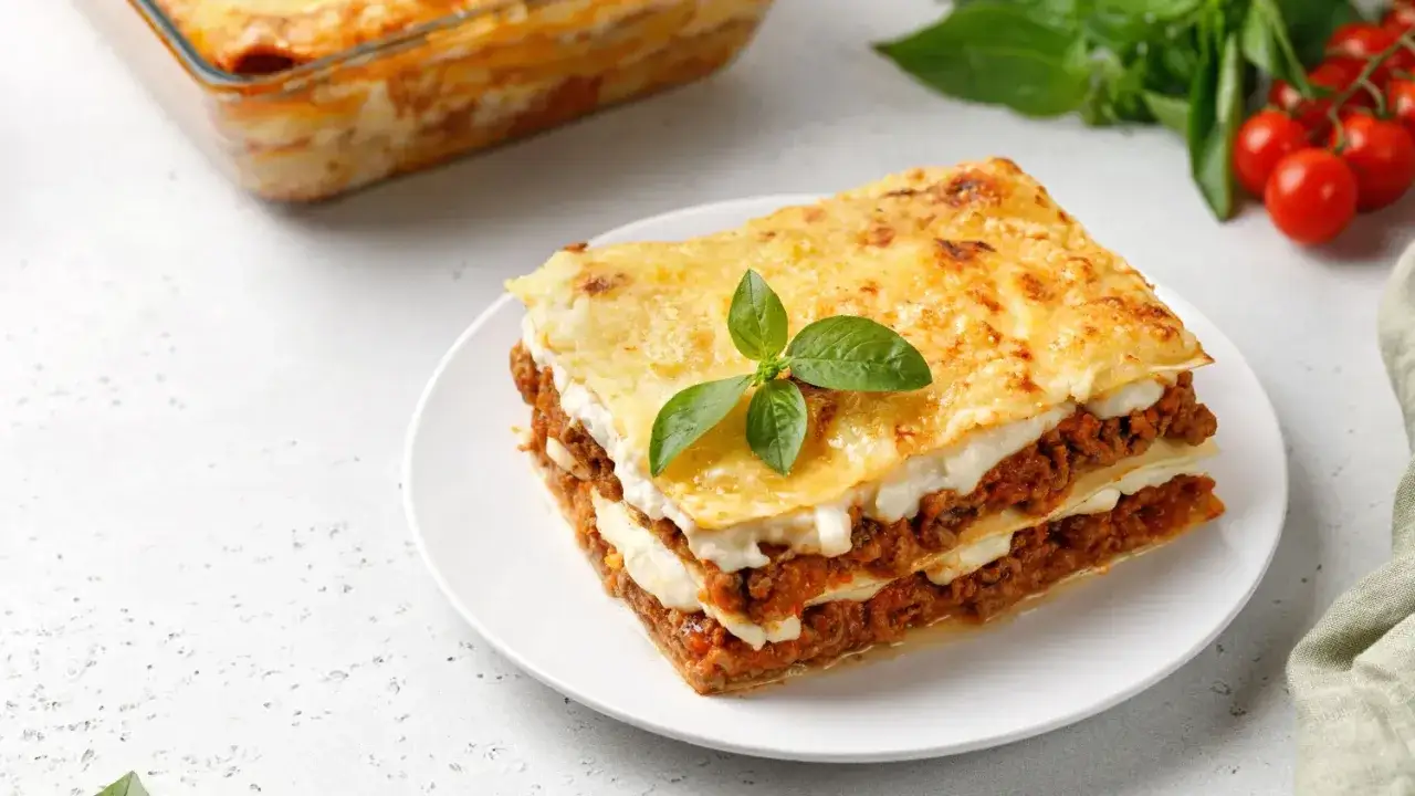 Une part de lasagnes au four, dor&eacute;e et app&eacute;tissante, garnie de basilic frais. Parfait pour r&eacute;chauffer les c&oelig;urs.