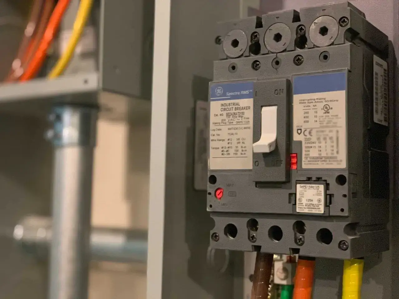 En industriell jordfelsbrytare, en GE Spectra RMS, är installerad med färgglada kablar.