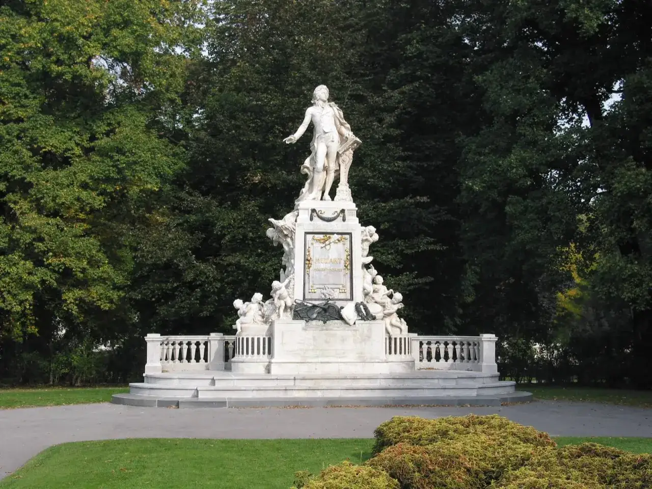 Pomnik Mozarta, wspaniały gr&oacute;b Mozarta, otoczony zielenią i rzeźbami putt&oacute;w.