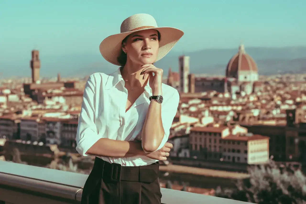 Elegancka kobieta w kapeluszu, uosobienie stylu włoscy projektanci mody, podziwia panoramę Florencji.