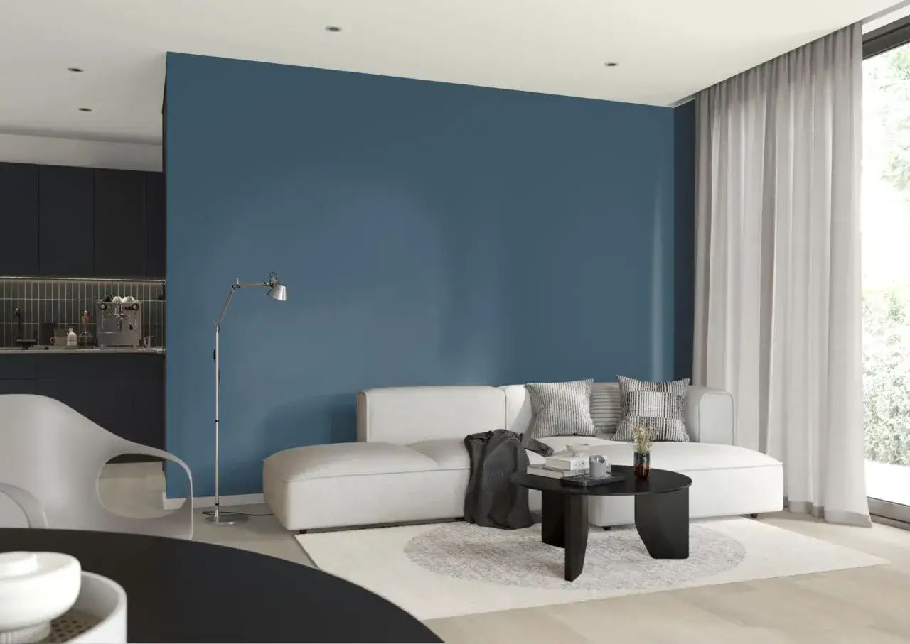 Nowoczesny salon z kanapą i stolikiem kawowym. Głęboki, granatowy pantone kolor ściany tworzy przytulną atmosferę.