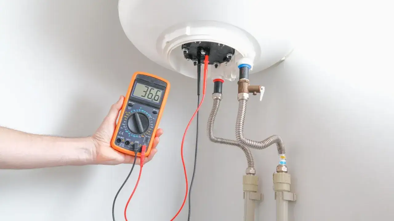 Come controllare un termostato con il tester: un multimetro arancione misura la temperatura di un boiler.