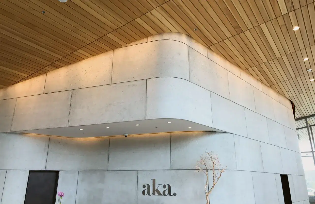 Moderne Lobby mit transluzentem Beton, Holzdecke und dem Schriftzug 