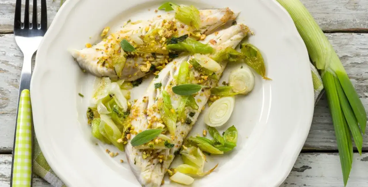 Poisson blanc cuit avec des poireaux tendres et des pistaches concassées. Une recette légère et savoureuse.
