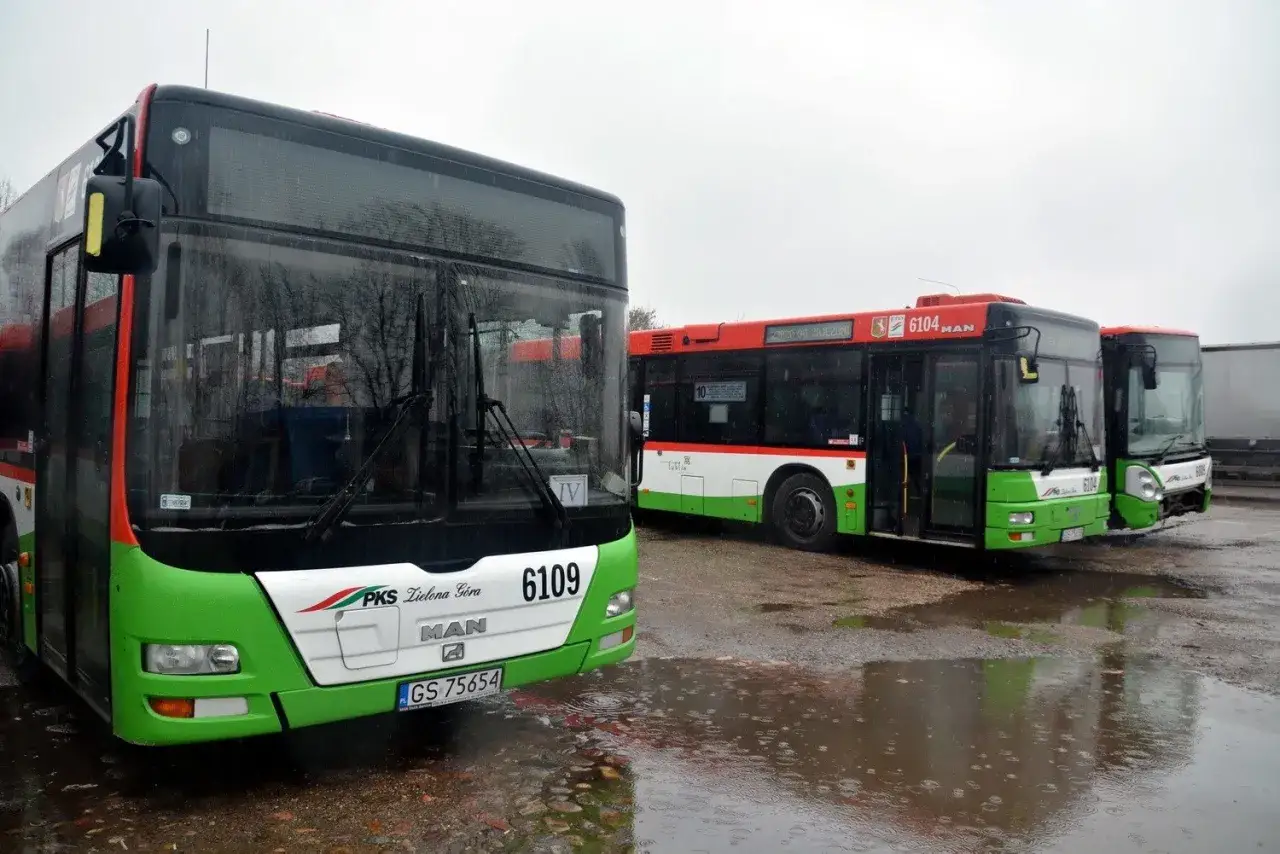 Autobusy PKS Zielona Góra stoją na mokrym placu. Jeden z nich ma numer 6109.