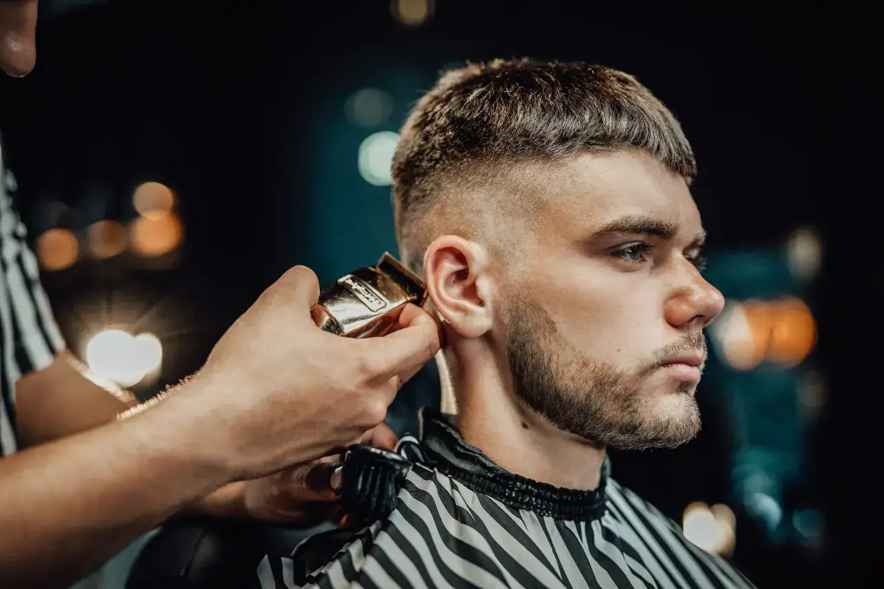 Ein Mann bekommt einen modernen French Crop Haarschnitt vom Barbier.
