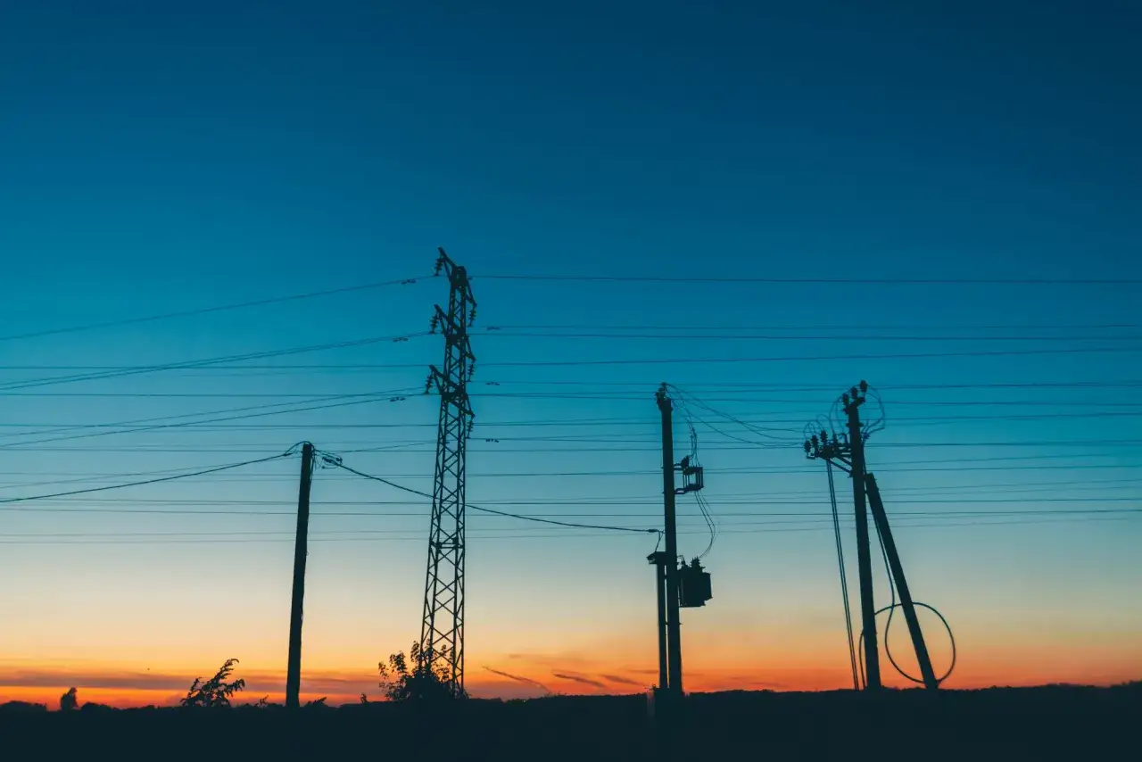 Zachód słońca nad liniami energetycznymi. Czy można uzyskać odszkodowanie za transformator na działce?