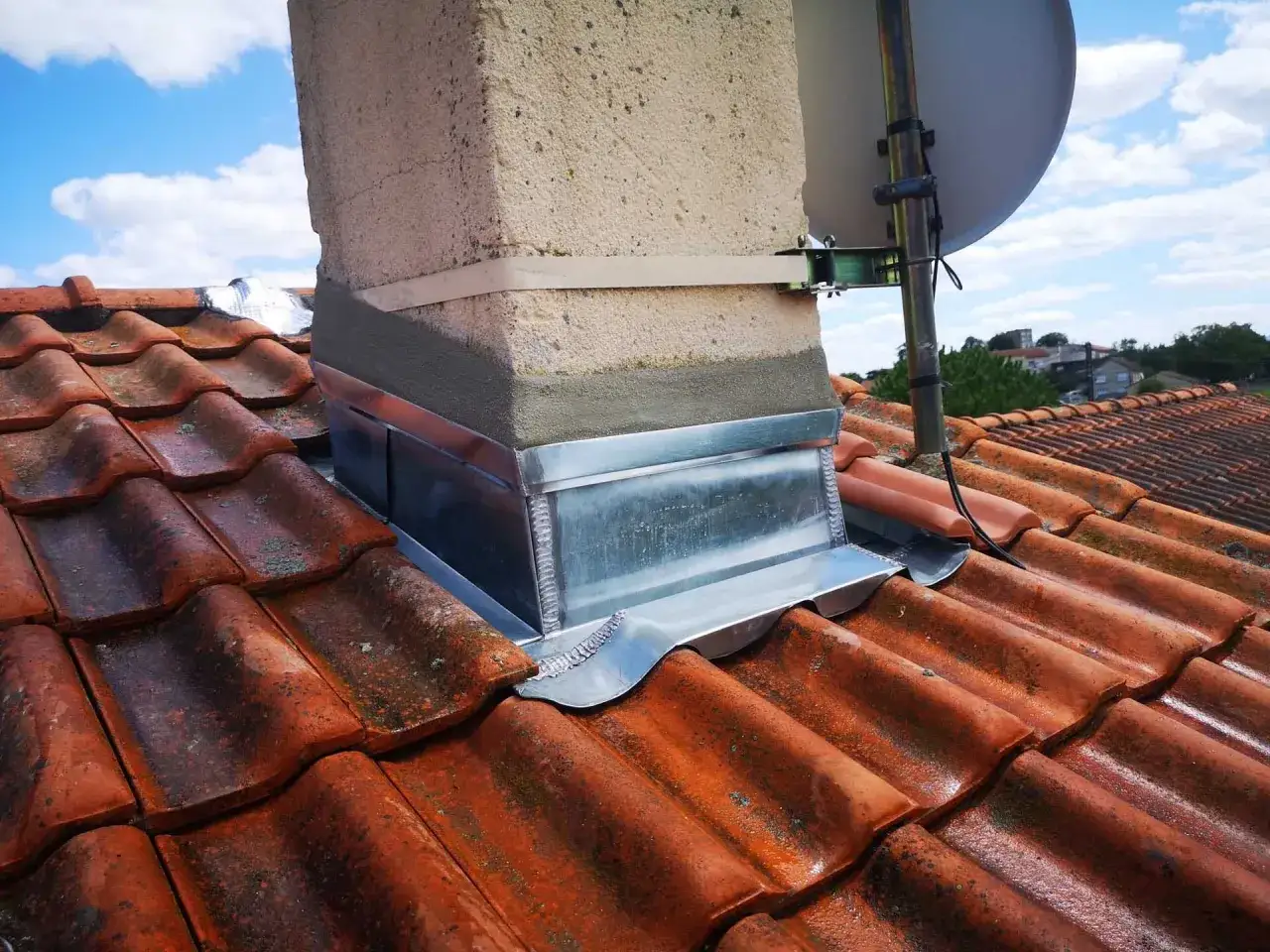 Travaux d'&eacute;tanch&eacute;it&eacute; de chemin&eacute;e sur toiture en tuiles. Un solin en zinc assure la parfaite imperm&eacute;abilit&eacute;.