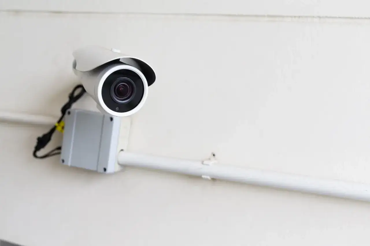 Kamera monitoringu na ścianie bloku, zapewniająca prywatny monitoring.