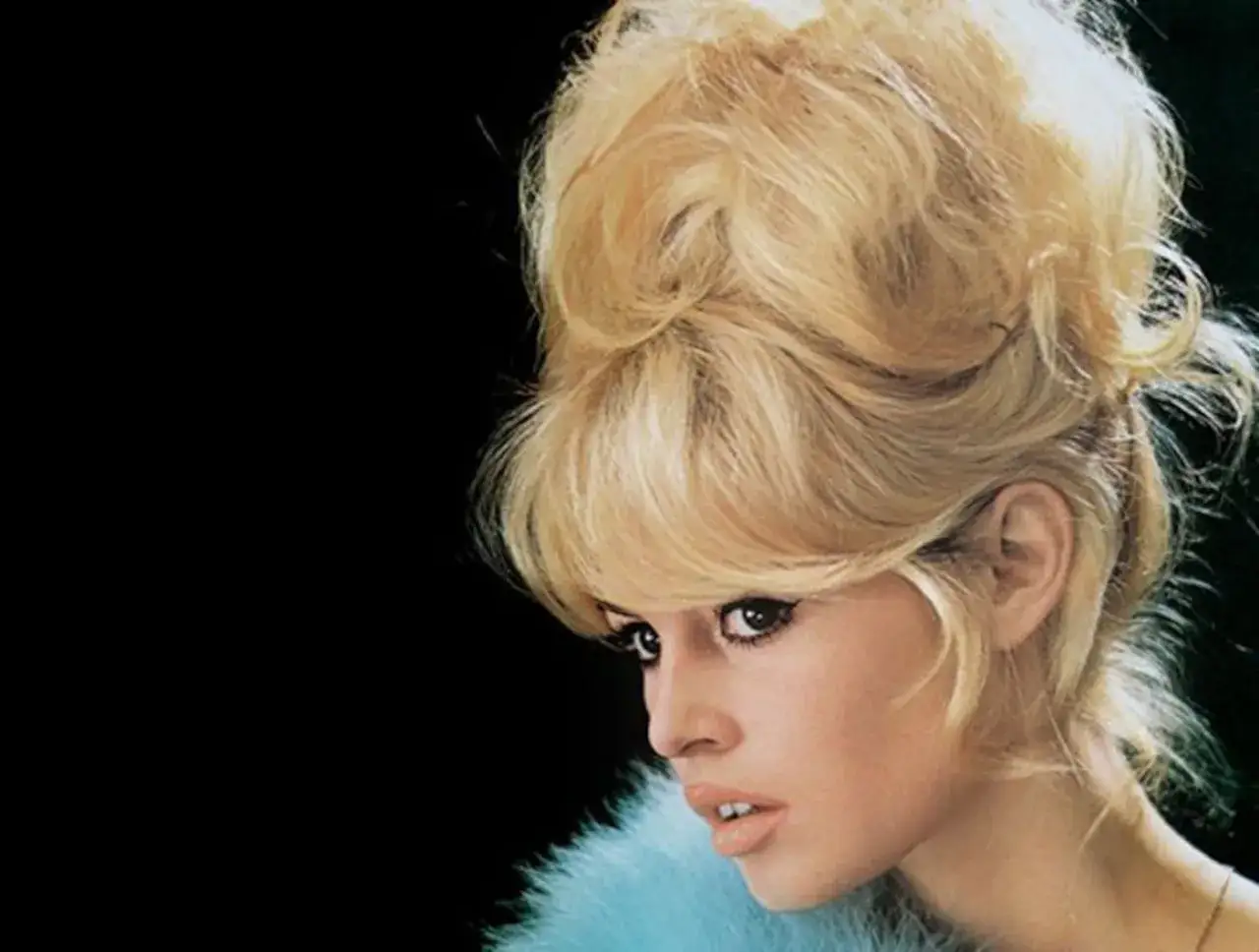 Icono de los moda peinados de los 60, con un voluminoso recogido rubio y maquillaje dramático.