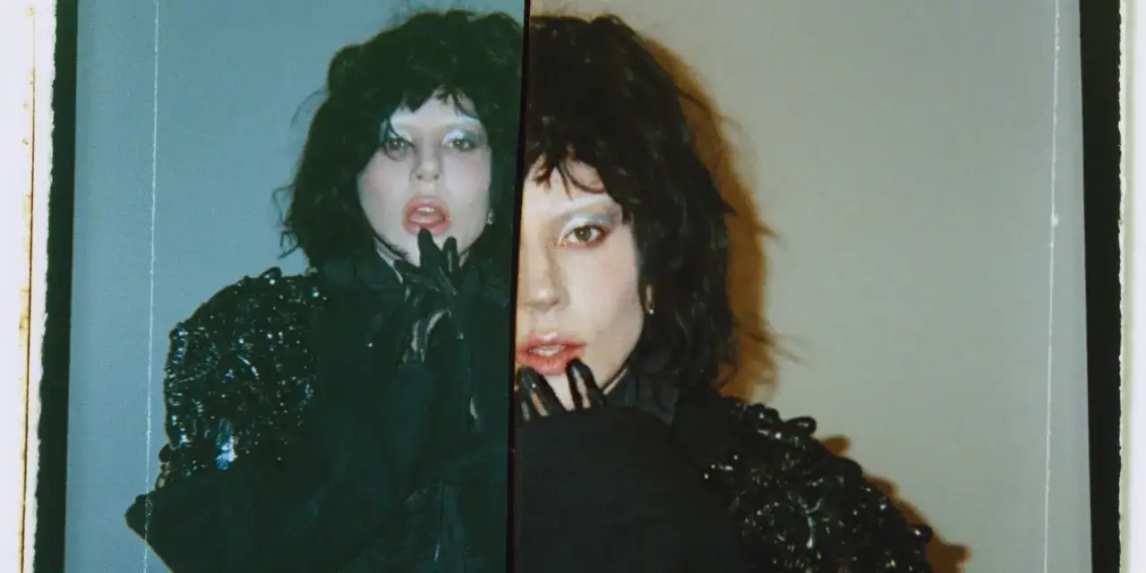 Lady Gaga w czarnej, błyszczącej kreacji, z charakterystycznym makijażem. To ujęcie przypomina jej **lady gaga poczatki kariery**, pełne dramatyzmu i wyrazistości.