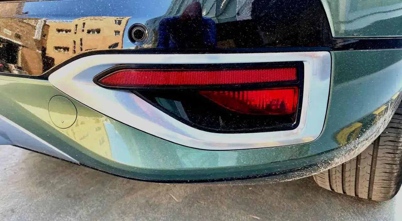 Detalle de un coche, mostrando el piloto trasero rojo y el contorno plateado. Este elemento, que es un catadi&oacute;ptrico, refleja la luz para mayor seguridad.