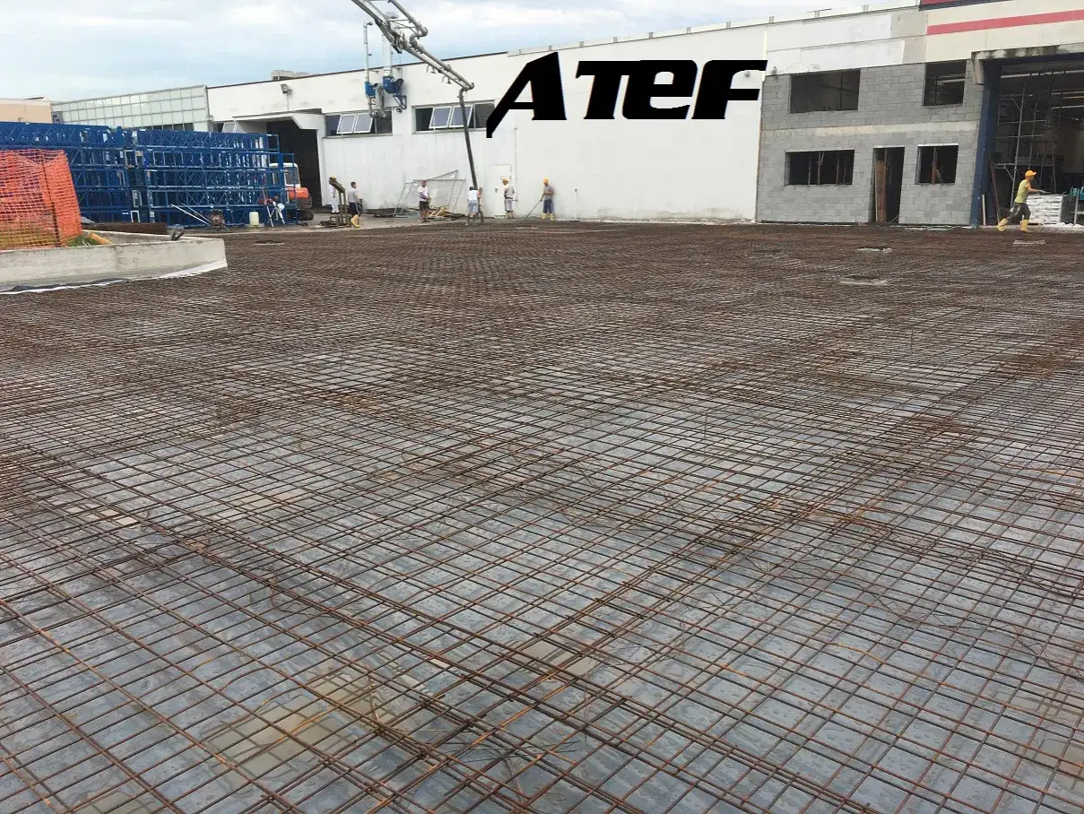 Preparazione per come fare il cemento per esterni: rete metallica posata su un'area di cantiere, pronta per il getto.