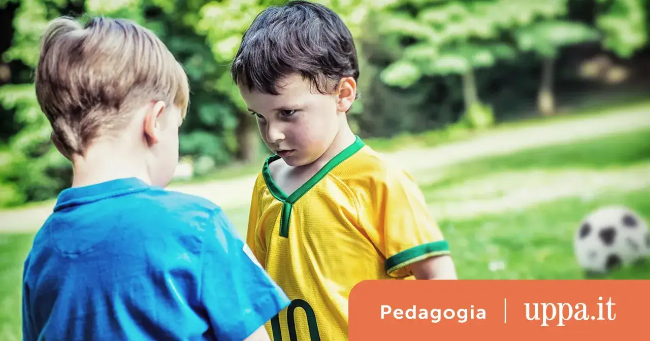 Due bambini si guardano intensamente in un prato. Se hai figli violenti a chi rivolgerti?