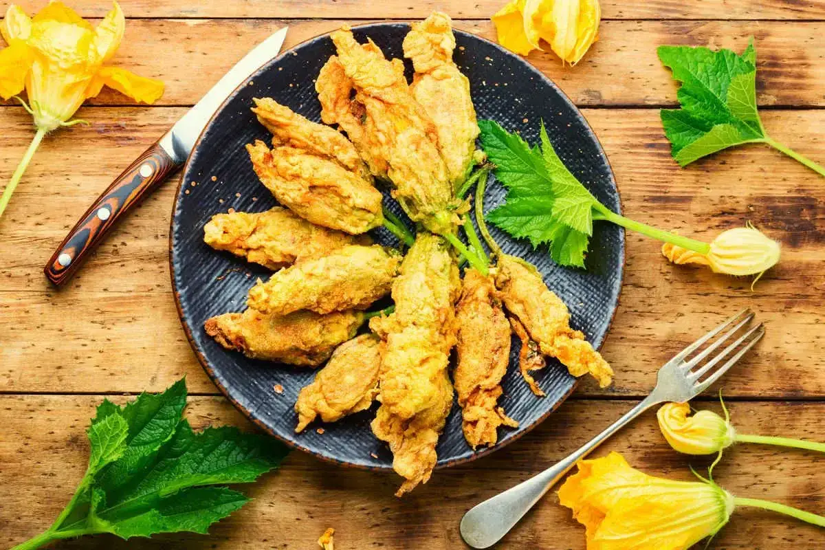 Fiori di zucca in friggitrice ad aria, dorati e croccanti, pronti per essere gustati.