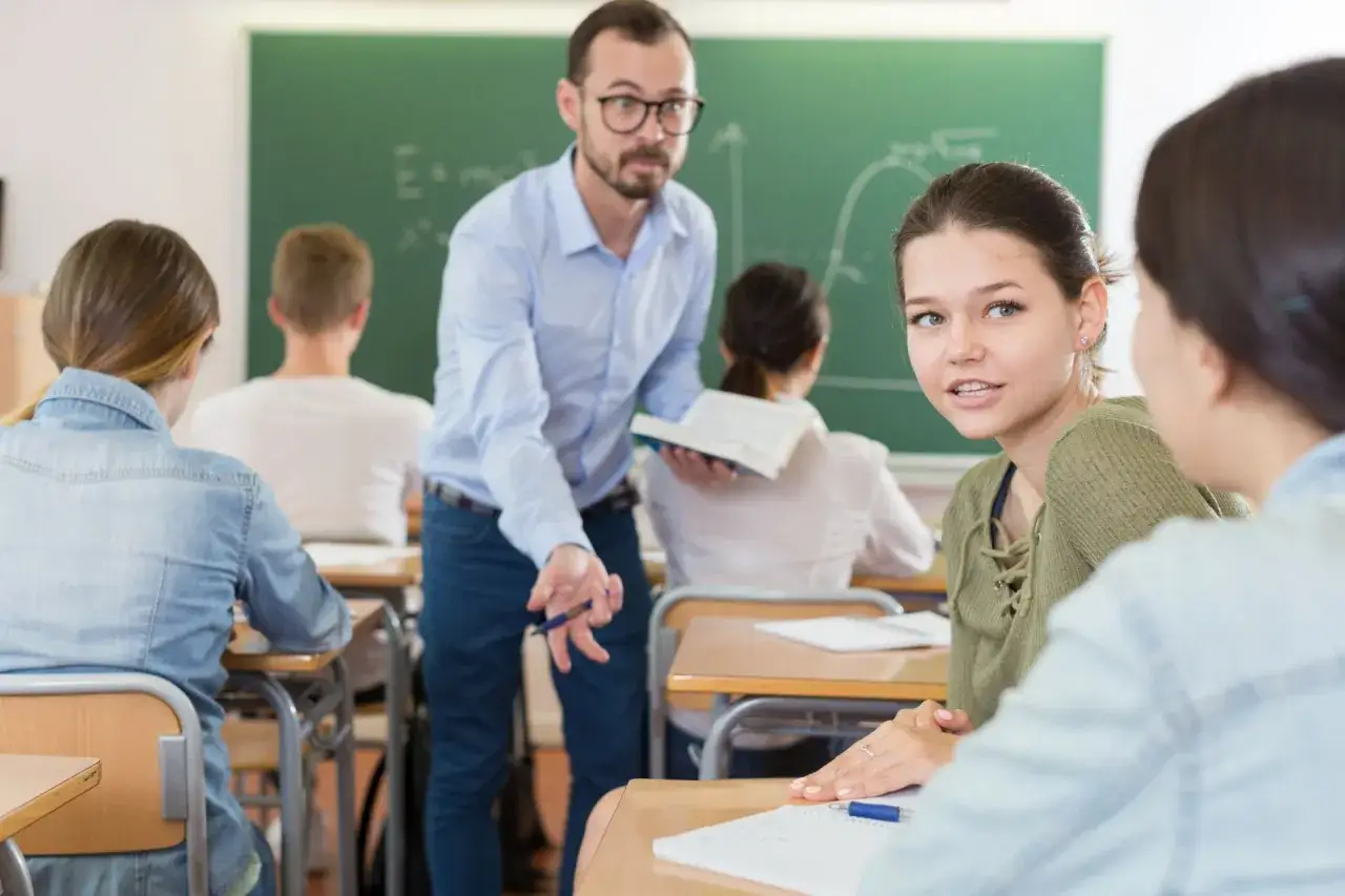 Lehrer erkl&auml;rt Mathe, wie bekommt man Respekt? Sch&uuml;lerinnen h&ouml;ren aufmerksam zu.