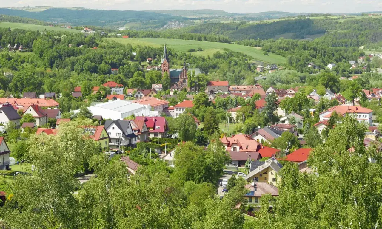 Widok na malownicze Ciężkowice, gdzie zielone wzgórza otaczają miasto, tworząc krajobraz jak ze skamieniałego miasta.