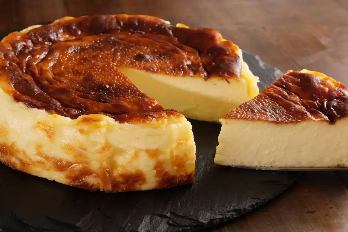 Una golosa cheesecake basca con la sua crosticina caramellata e un interno cremoso, pronta per essere gustata.