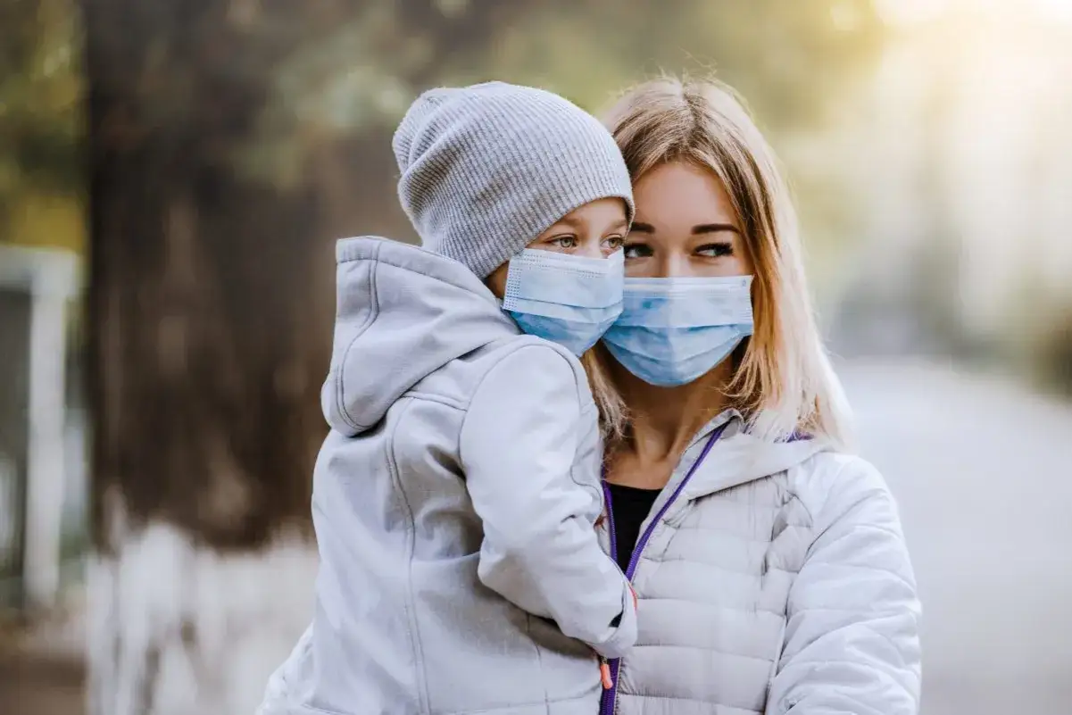 Madre e hijo con mascarillas. El resfriado por enfriamiento se contagia, por eso se protegen.