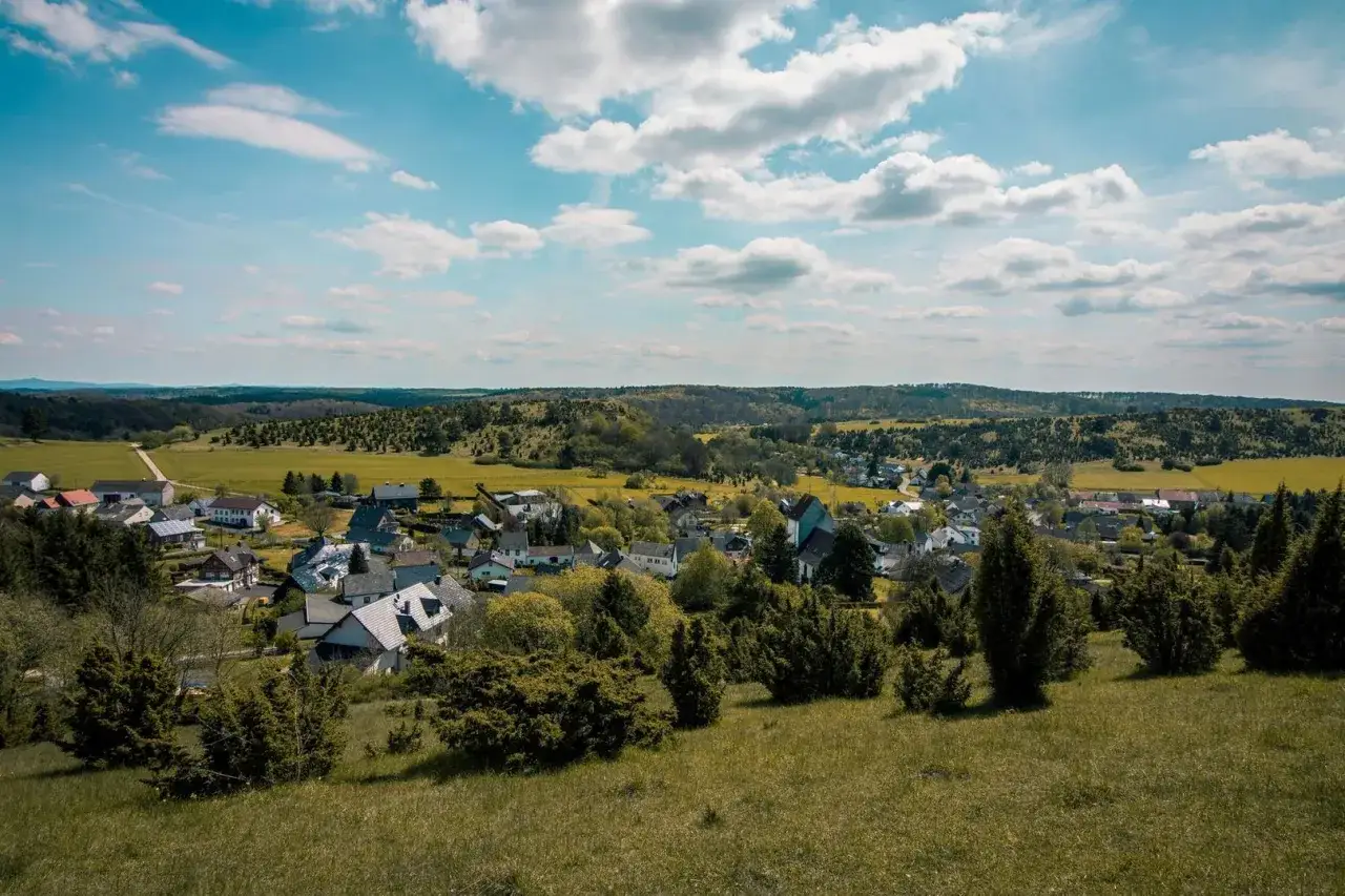 Idyllisches Dorf mit roten D&auml;chern und gr&uuml;nen H&uuml;geln, das an die Toskana erinnert &ndash; die Toskana der Eifel.