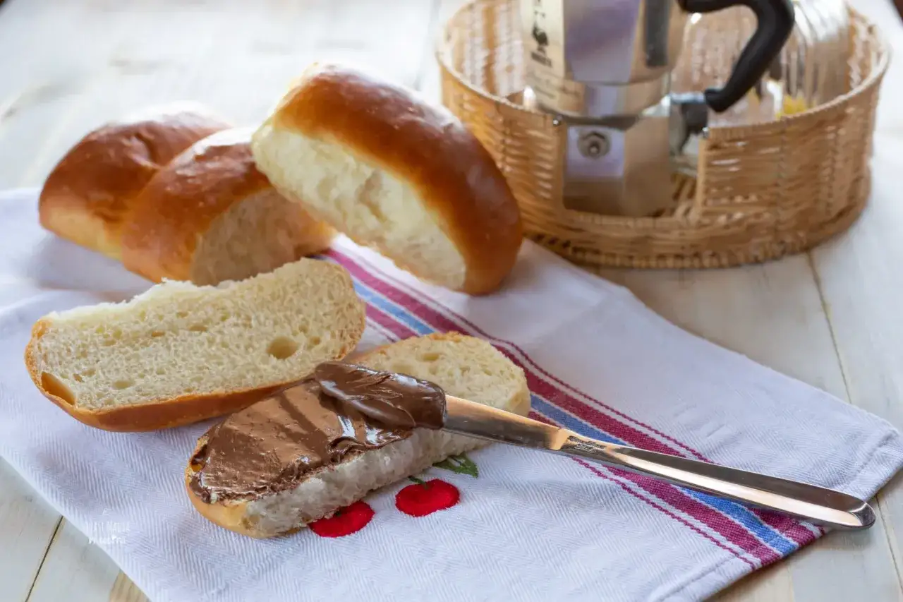 Dolci panini dorati, perfetti per gustare un maritozzo marchigiano con crema al cioccolato.