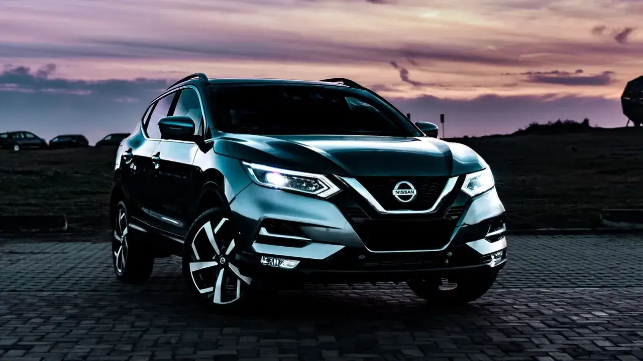 Mörkgrå Nissan Qashqai parkerad vid solnedgången. Kanske ett problem med bilen?
