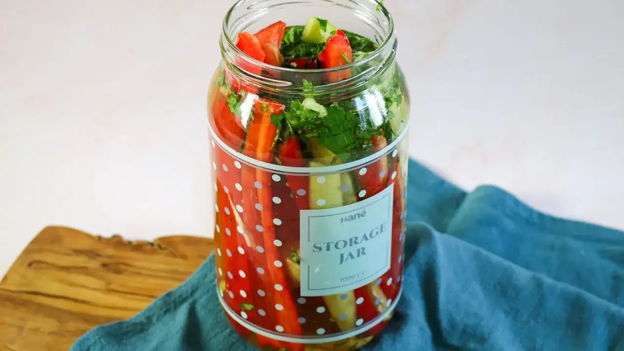 Bunte Paprika und Kräuter im Glas, bereit zum Einkochen im Weck-Glas.