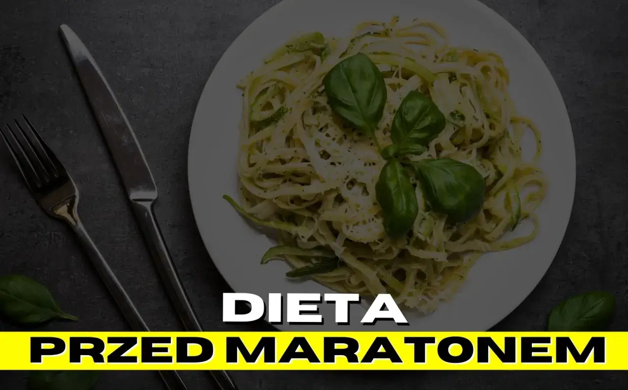 Talerz makaronu z bazylią i cukinią, idealny na dietę przed maratonem. Obok sztućce.