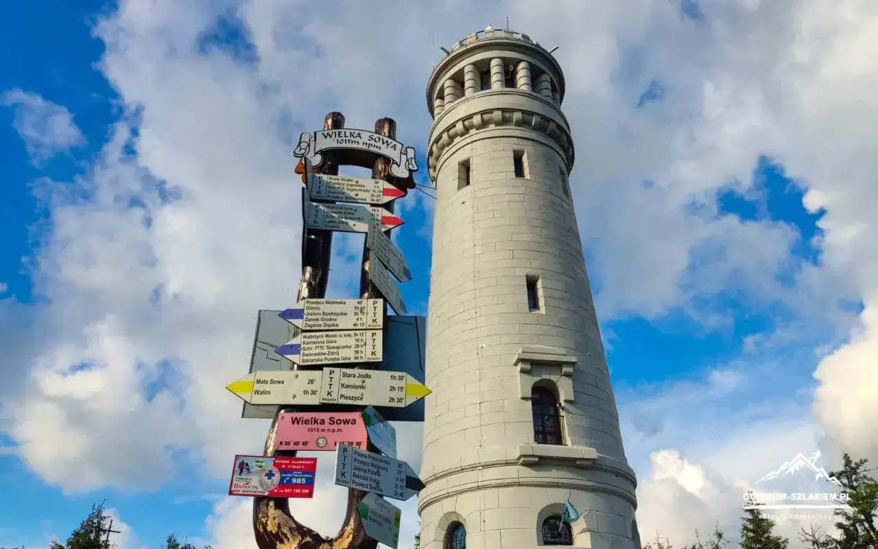Wieża widokowa na Wielkiej Sowie, obok drogowskaz&oacute;w turystycznych. Schronisko Sowa to cel wielu wędr&oacute;wek.