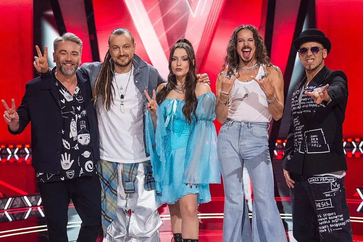 Jurorzy The Voice Kids pozują na scenie, pozdrawiając publiczność.